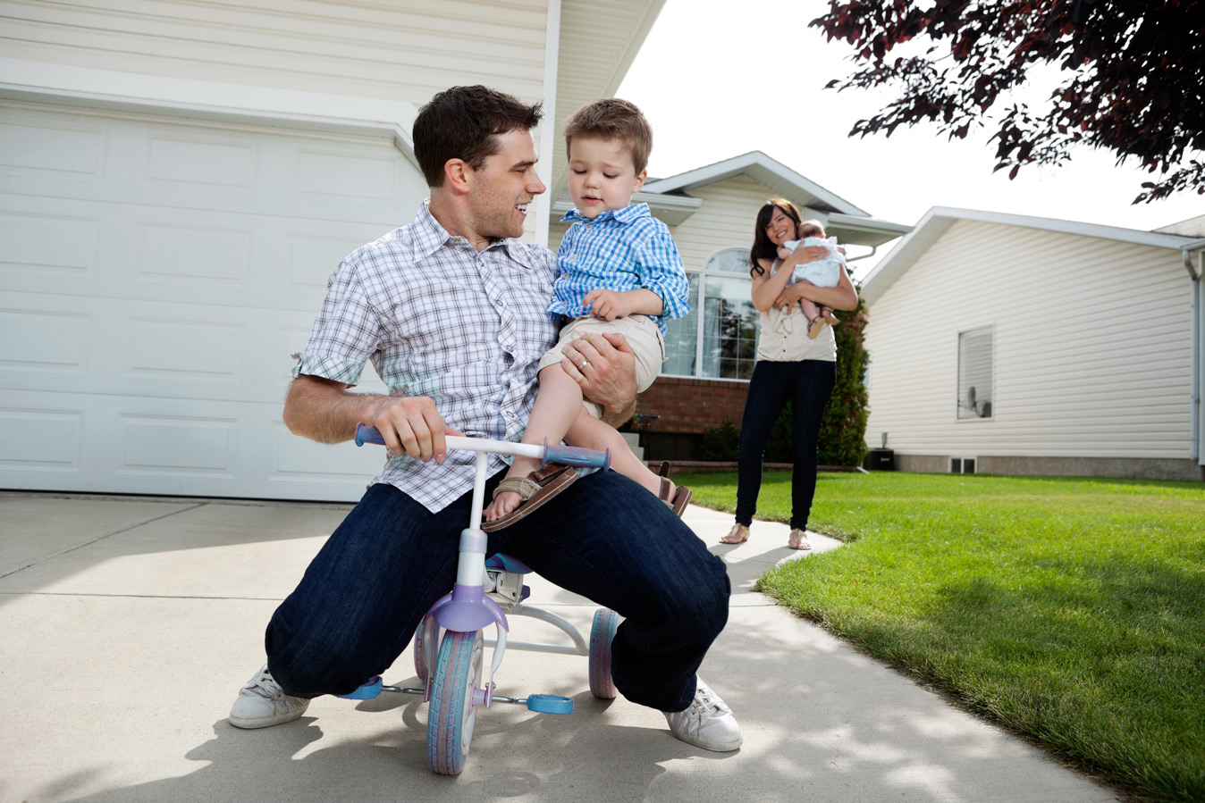 young happy family playing outside of house