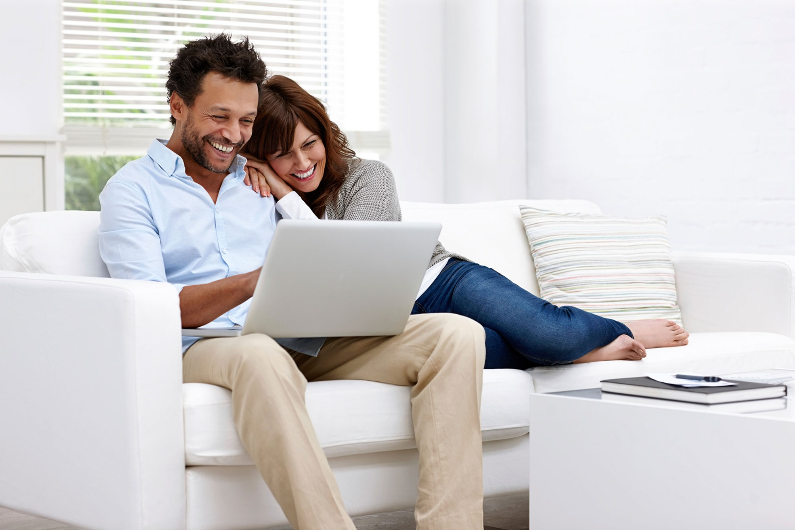 happy couple on couch with laptop 